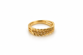 Gold-tone decorative ring with overlapping diagonal leaf-like curves and a central row of small clear stones, shown on a white background and worn on a finger.