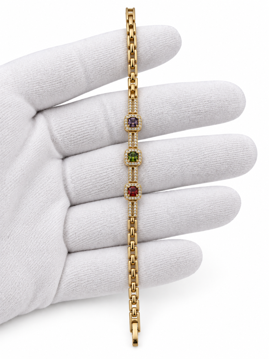 Gold-tone bracelet with three square purple, green and red decorative accents framed by clear-looking stones, double-row chain detailing and a clasp closure.
