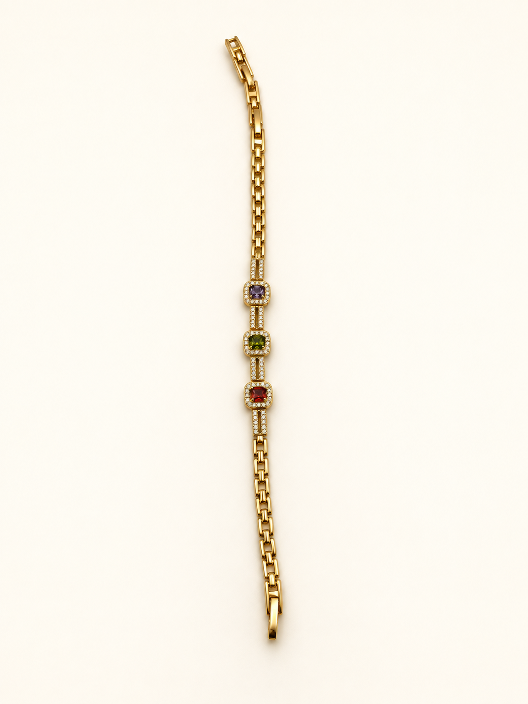 Gold-tone bracelet with three square purple, green and red decorative accents framed by clear-looking stones, double-row chain detailing and a clasp closure.