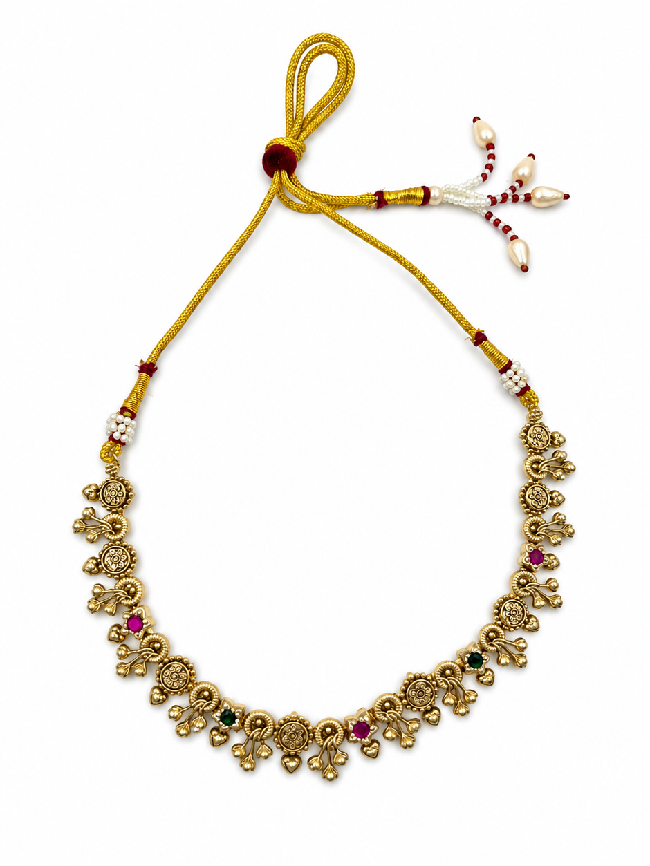Traditional gold-tone floral necklace set with matching dangling earrings, featuring magenta and green accents, ivory-white bead-like details and intricate ornamental motifs.