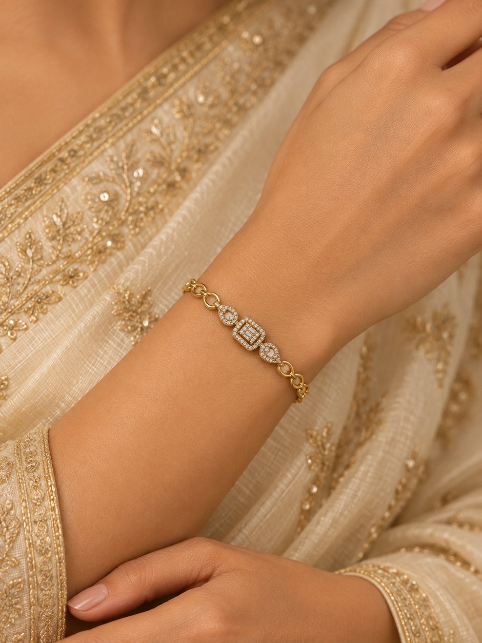 Gold-tone bracelet with three square purple, green and red decorative accents framed by clear-looking stones, double-row chain detailing and a clasp closure.