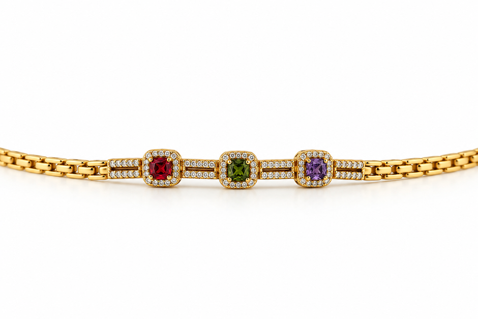 Gold-tone bracelet with three square purple, green and red decorative accents framed by clear-looking stones, double-row chain detailing and a clasp closure.