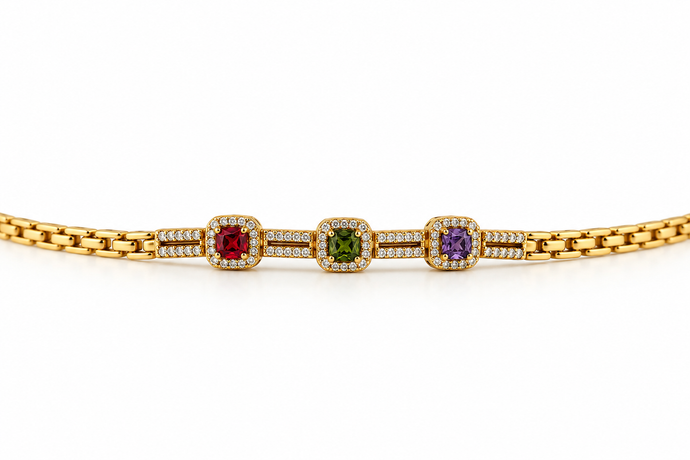 Gold-tone bracelet with three square purple, green and red decorative accents framed by clear-looking stones, double-row chain detailing and a clasp closure.