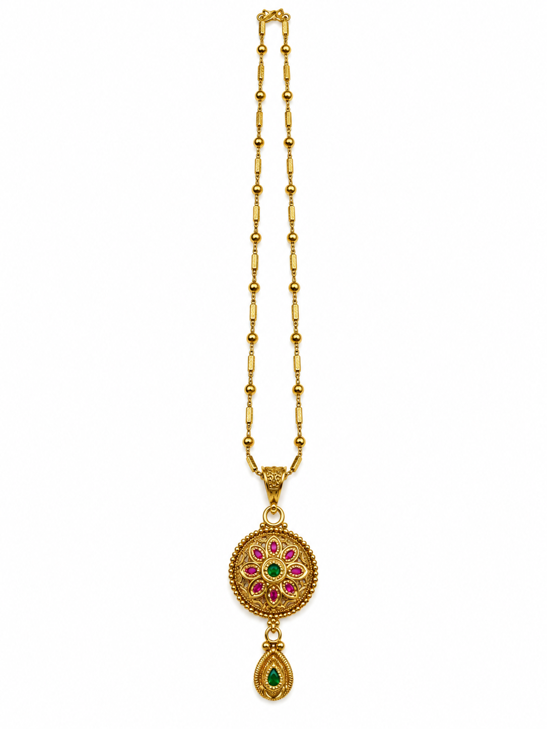 Gold-tone floral pendant necklace set displayed on white jewellery stands, featuring green and magenta-pink accents, a beaded chain, and matching earrings with green teardrop-shaped drops.