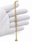 Gold-tone bracelet with three square purple, green and red decorative accents framed by clear-looking stones, double-row chain detailing and a clasp closure.