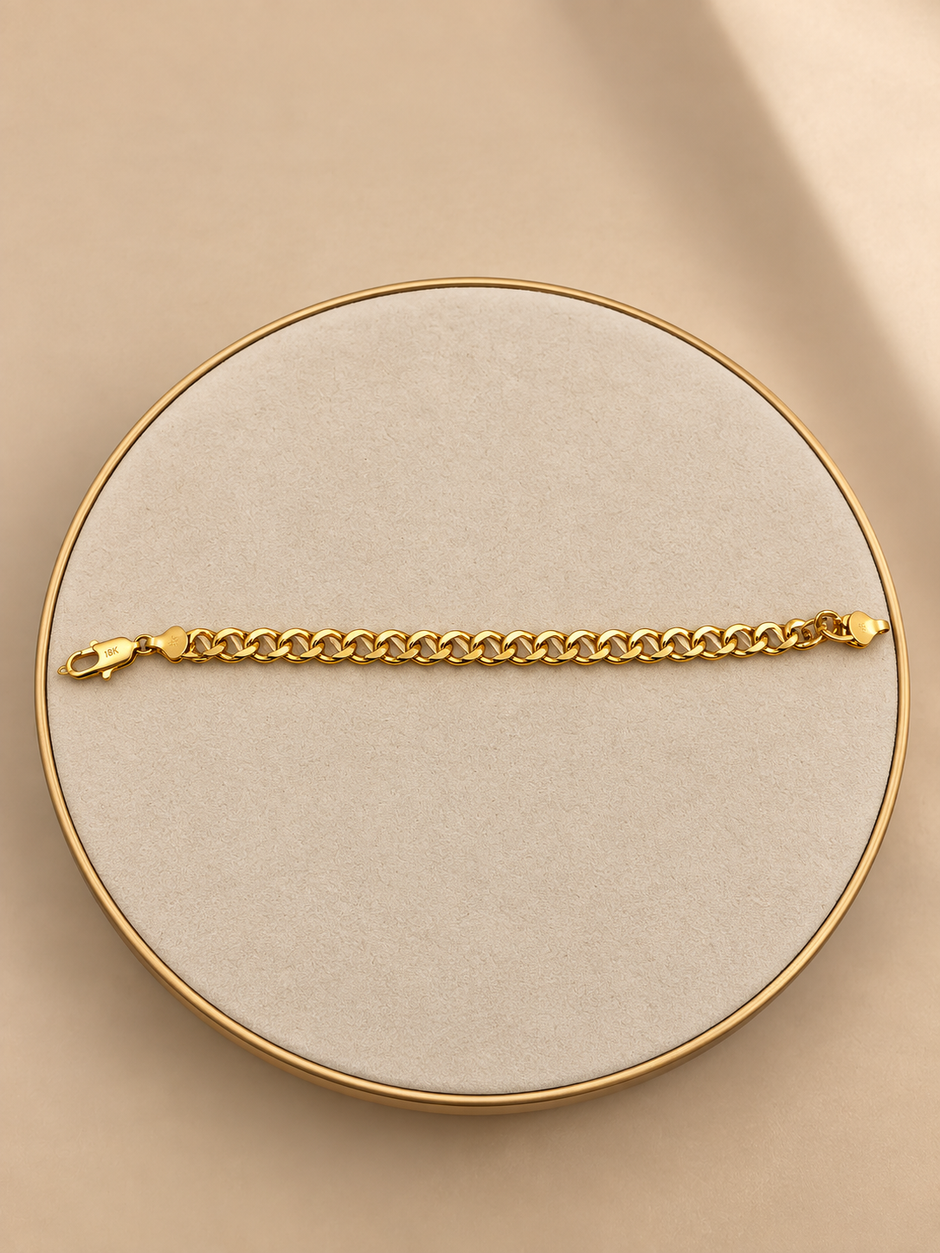 Gold-tone bracelet featuring a continuous chain of rounded interlocking links with a twisted appearance, shown separately and worn around a woman's wrist.