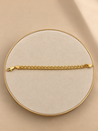 Gold-tone bracelet featuring a continuous chain of rounded interlocking links with a twisted appearance, shown separately and worn around a woman's wrist.