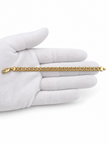 Gold-tone bracelet featuring a continuous chain of rounded interlocking links with a twisted appearance, shown separately and worn around a woman's wrist.