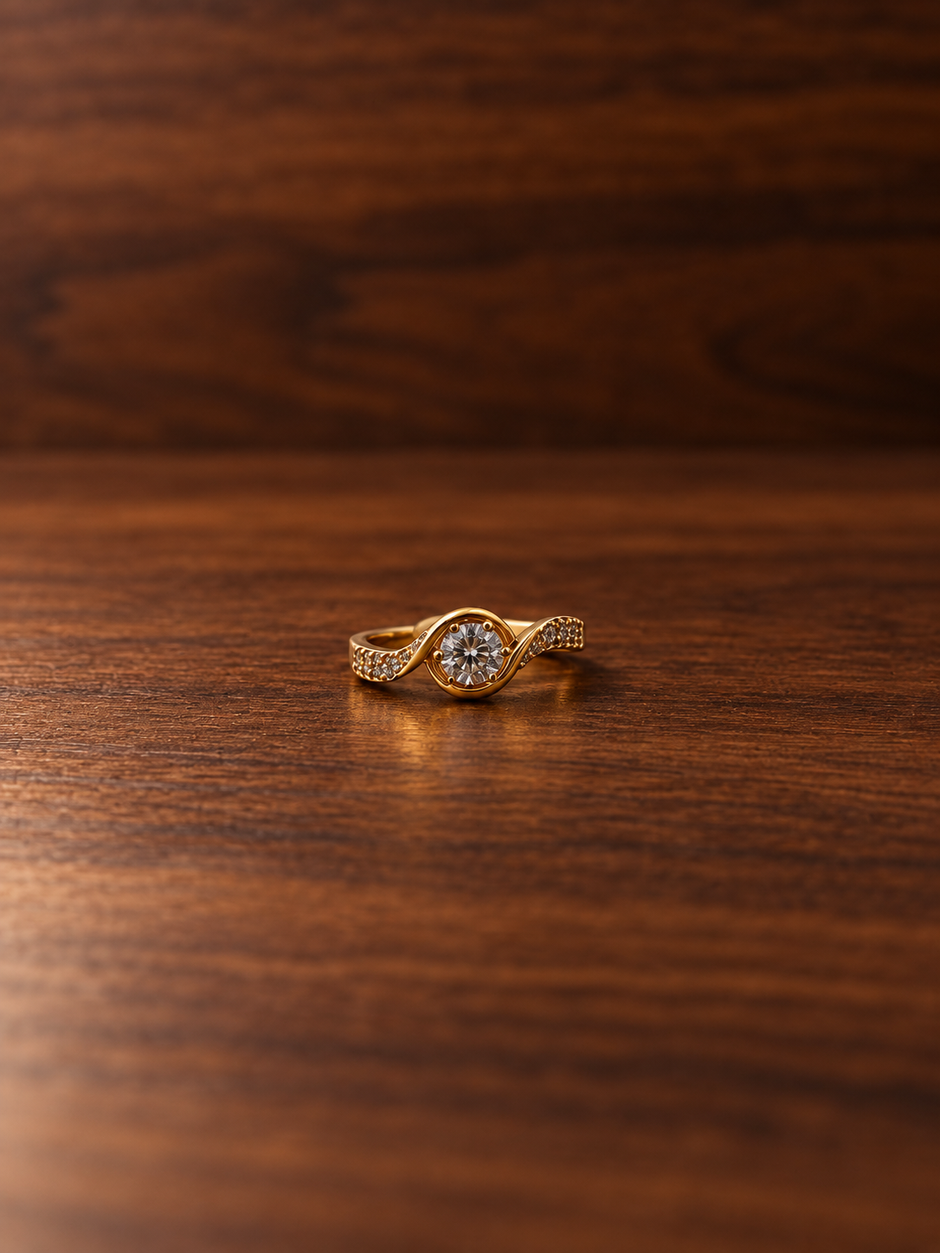 Gold-tone ring with a round floral arrangement of clear stones, curved golden detailing and small clear accents along the band, shown on a white background and worn on a finger.