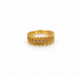 Gold-tone decorative ring with overlapping diagonal leaf-like curves and a central row of small clear stones, shown on a white background and worn on a finger.