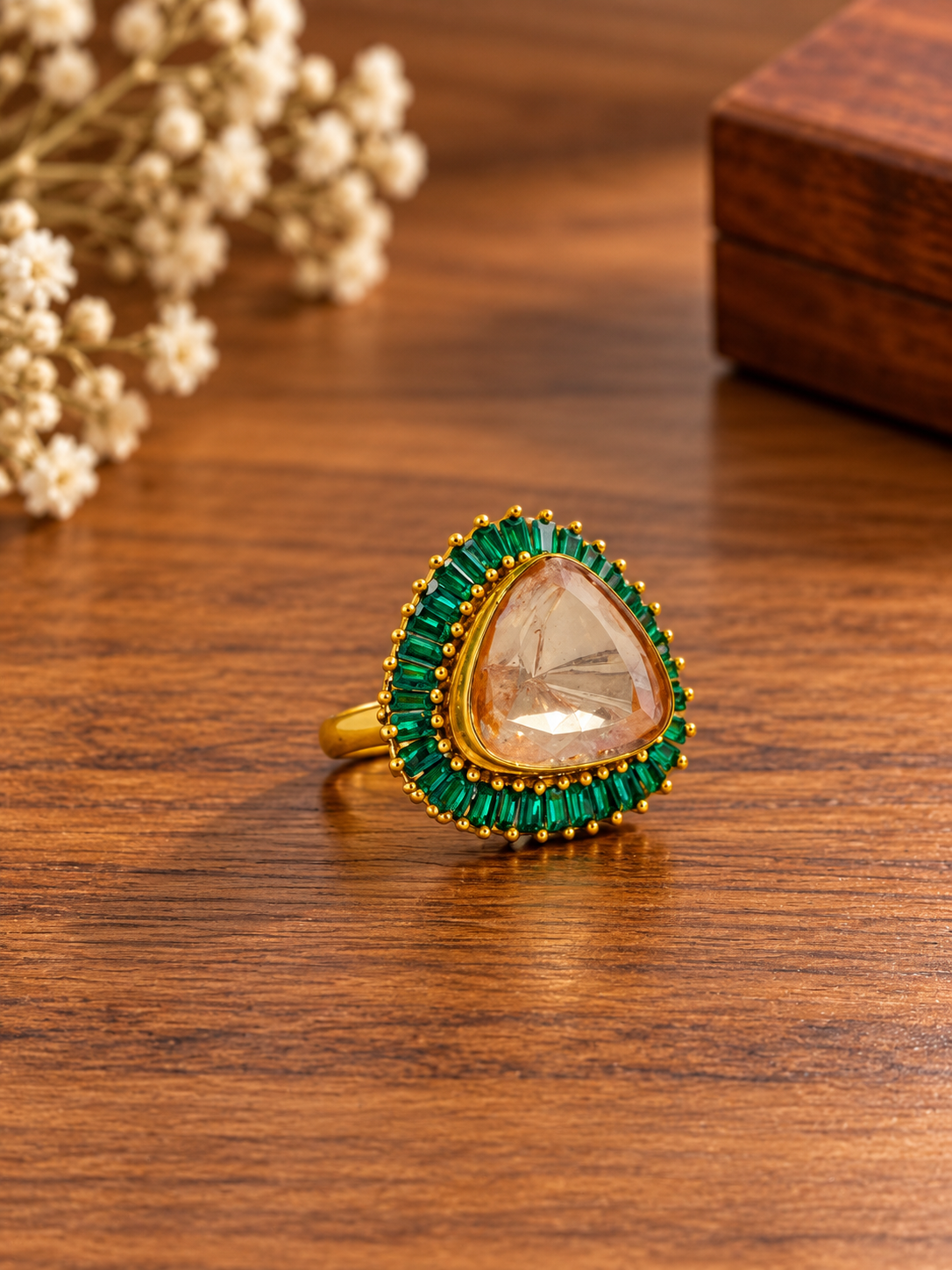 Bhavmayi gold-tone statement ring with green rectangular stones surrounding a large rounded triangular centre