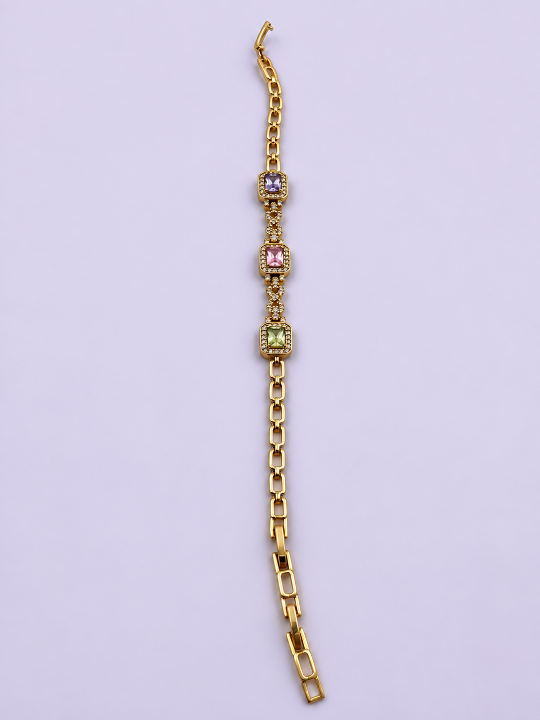 Gold-tone link bracelet with three rectangular purple, pink and green stones in square clear-stone settings, shown from the front and reverse.