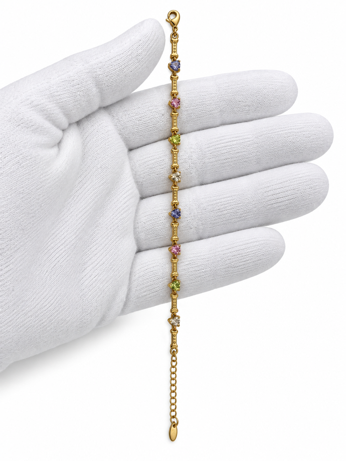 Gold-tone chain bracelet featuring geometric golden links and multicoloured blue, purple, pink, green and clear decorative accents, shown separately and worn on a wrist.
