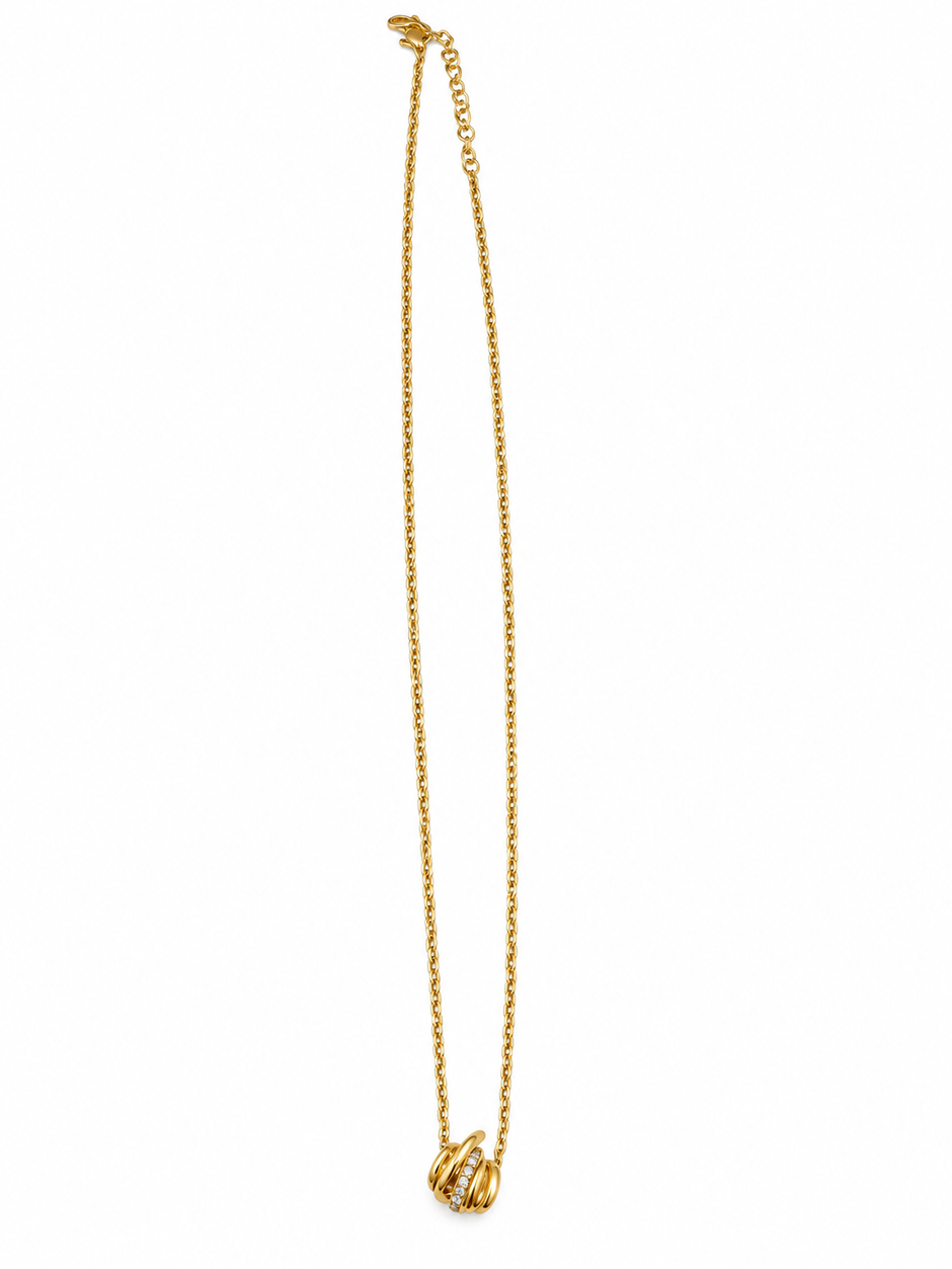 Gold-tone necklace with a fine linked chain and a small layered curved pendant featuring clear reflective stones, displayed on a black jewellery bust and a white gloved hand.
