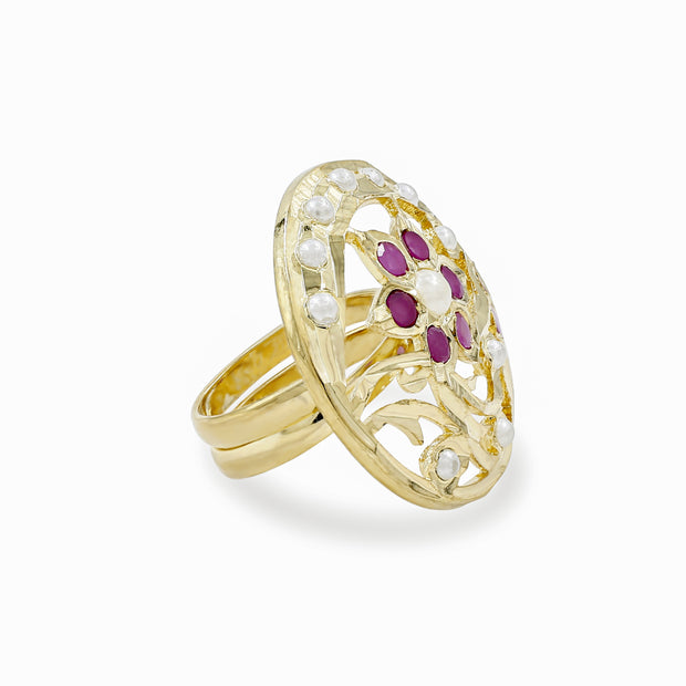 A gold filigree ring featuring a floral motif with white stones and a central cluster of purple gemstones, shown on a clean white background.