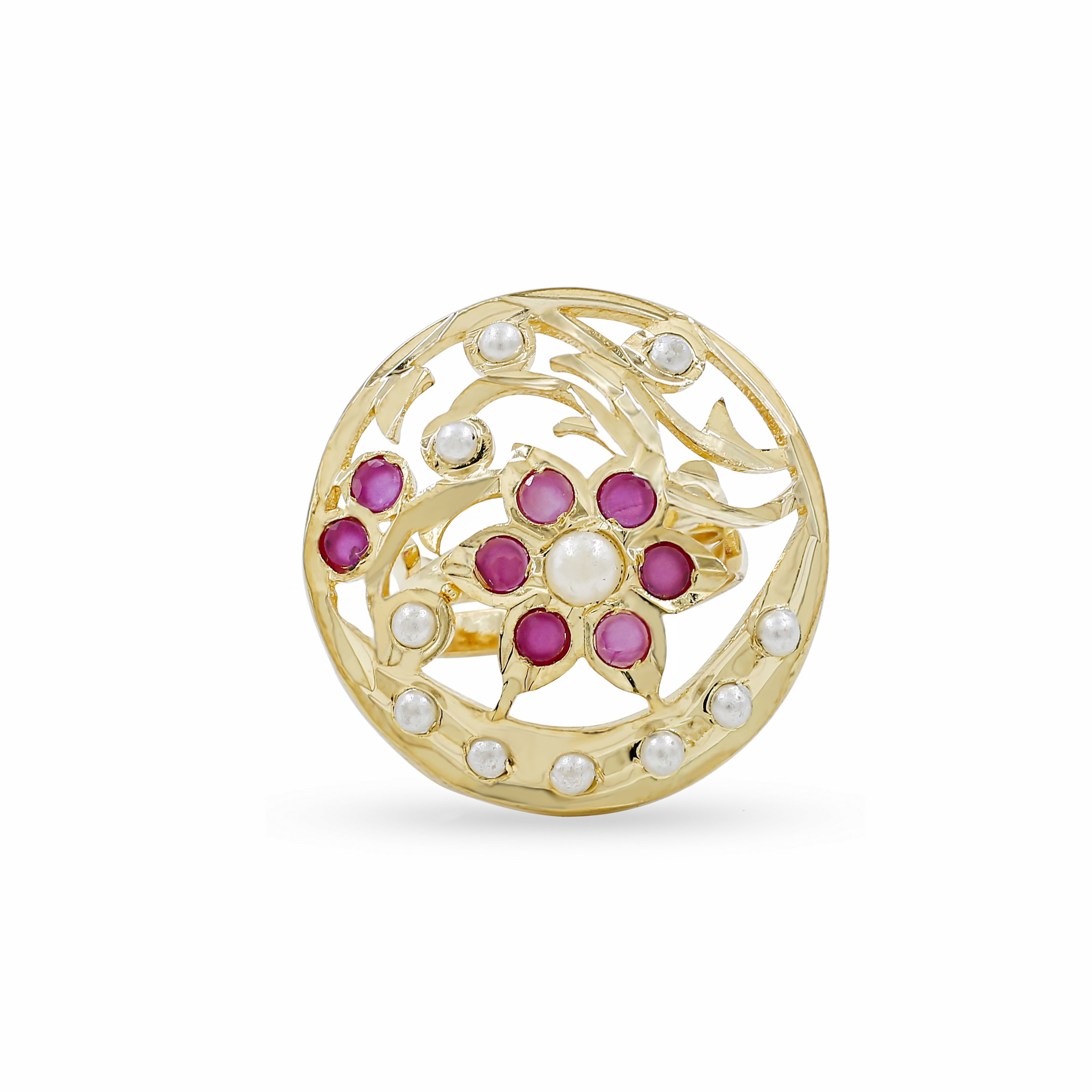 A round gold filigree brooch featuring a central floral motif with pinkish-red gemstones and white pearl-like accents, set against a plain white background.