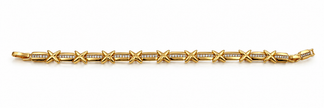 Gold-tone bracelet with blue, pink, green and clear square-shaped accents, decorative links, a lobster-style clasp and an extension chain, held against a white background.