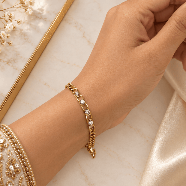 Bhavmayi golden bracelets with varied link designs and clear sparkling stone-like accents shown worn on the wrist
