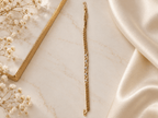 Bhavmayi golden bracelets with varied link designs and clear sparkling stone-like accents shown worn on the wrist
