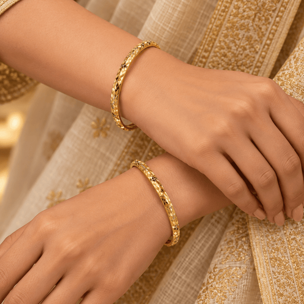Bhavmayi gold-tone bangle pair with slim circular bands and faceted geometric textured detailing - bhavmayi