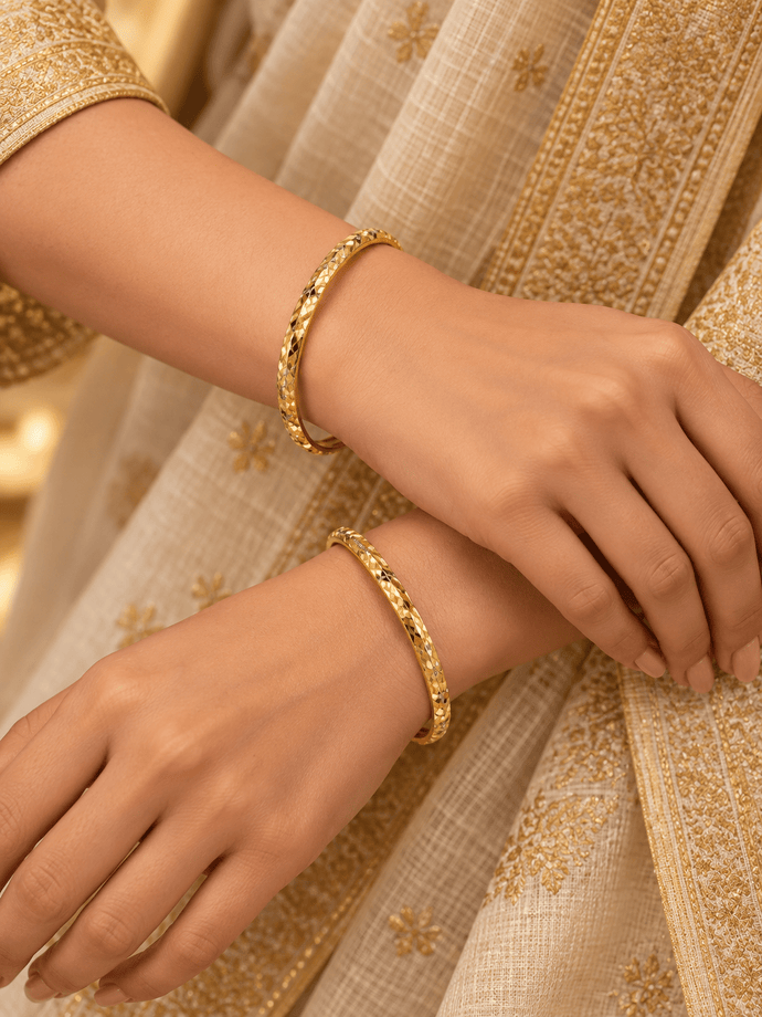Bhavmayi gold-tone bangle pair with slim circular bands and faceted geometric textured detailing - bhavmayi