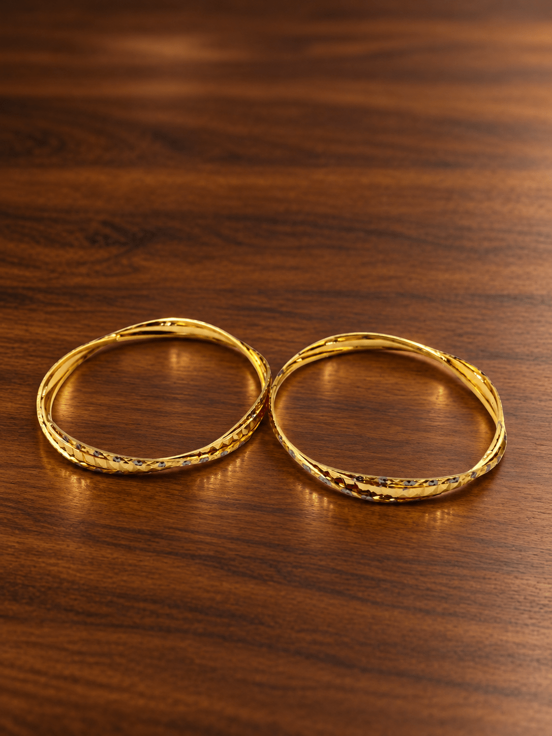 Bhavmayi gold-tone bangle pair with slim circular bands and faceted geometric textured detailing - bhavmayi