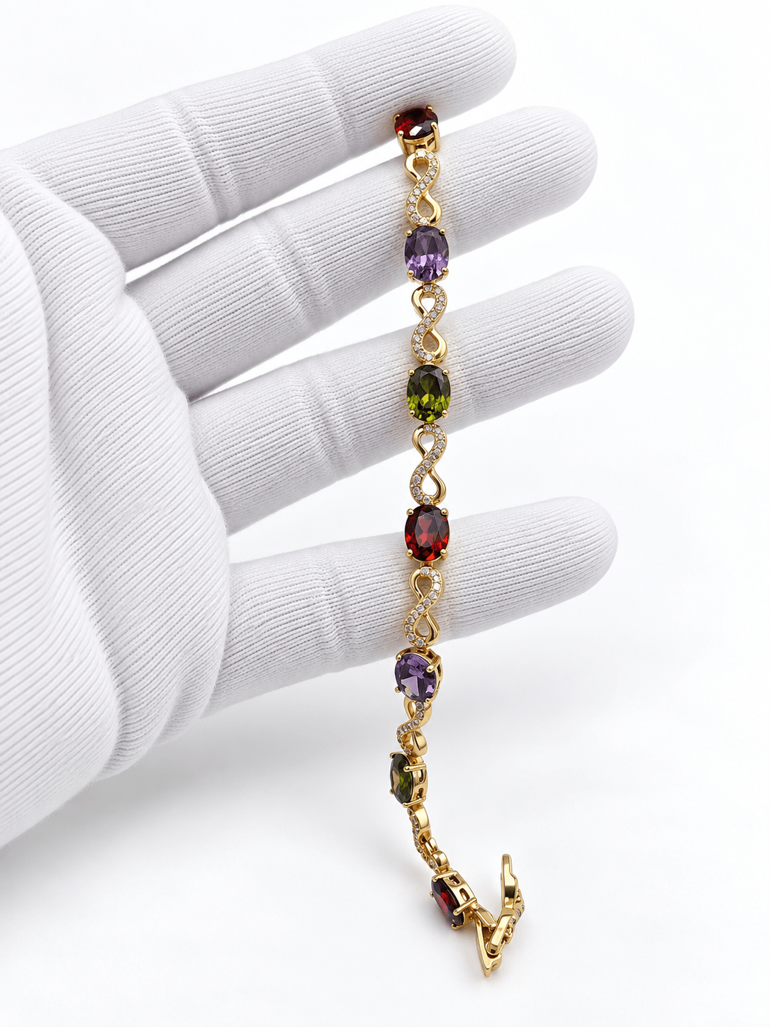 Golden-toned multicolor bracelet with red purple and green oval accents and clear decorative link details