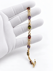 Golden-toned multicolor bracelet with red purple and green oval accents and clear decorative link details