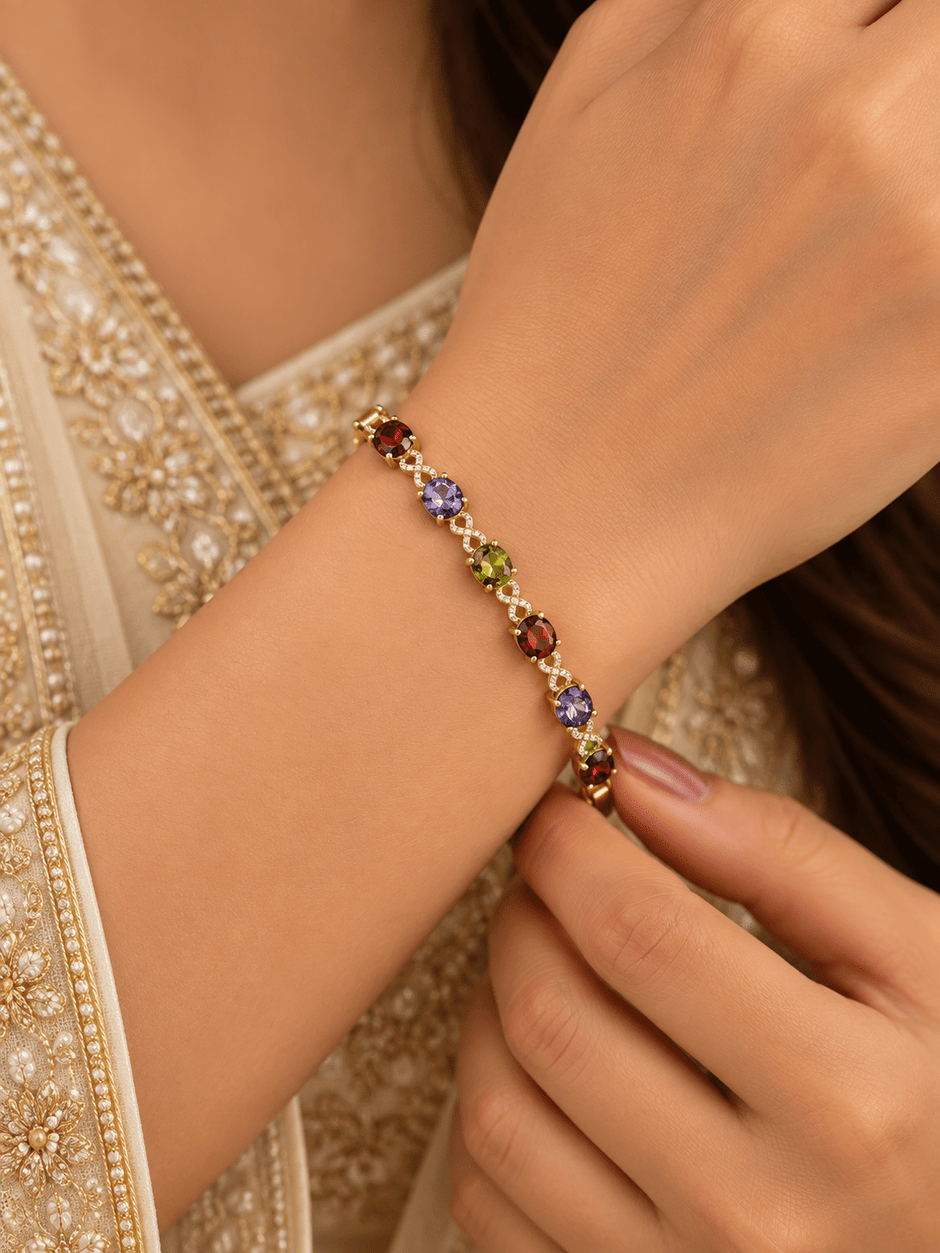 Golden-toned multicolor bracelet with red purple and green oval accents and clear decorative link details