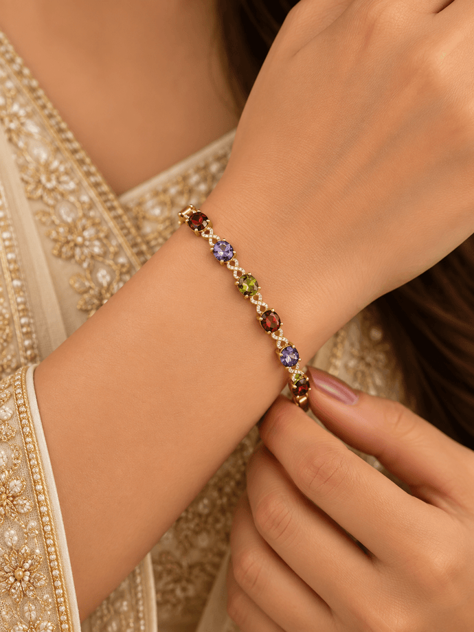 Golden-toned multicolor bracelet with red purple and green oval accents and clear decorative link details
