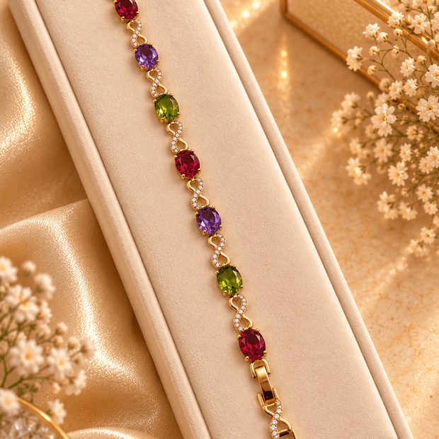Golden-toned multicolor bracelet with red purple and green oval accents and clear decorative link details