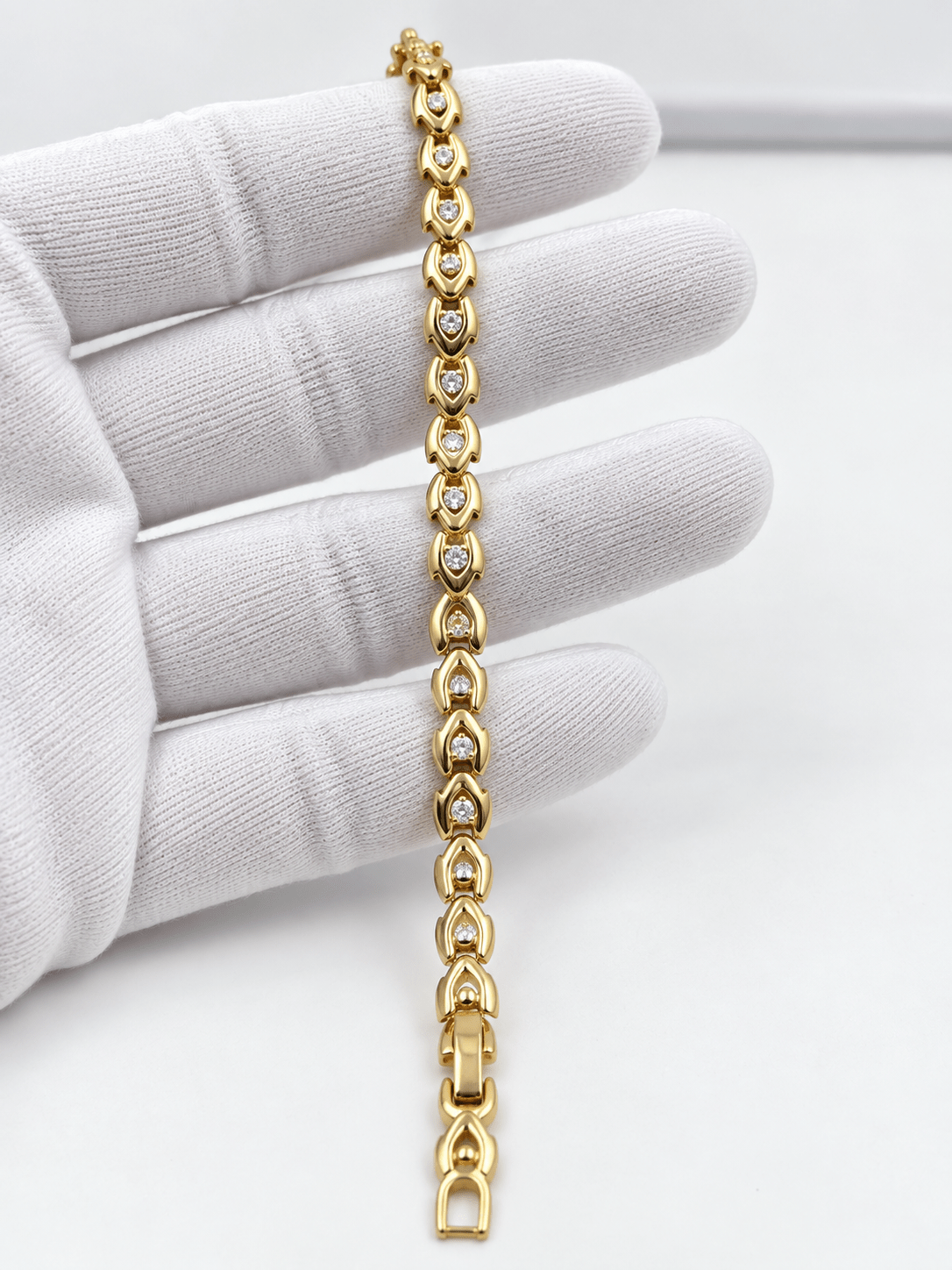 Bhavmayi gold-tone oval link bracelet with repeating clear accents and rounded decorative connectors - bhavmayi