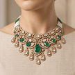 Bhavmayi gold-tone traditional choker necklace with a central green teardrop stone, white accents and ornate hanging motifs - bhavmayi