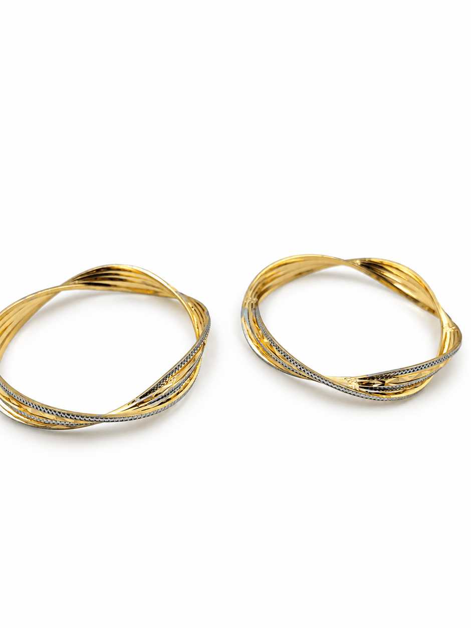 Pair of golden-toned twisted bangles with layered curved bands and contrasting textured detailing