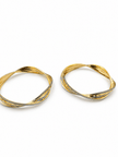 Pair of golden-toned twisted bangles with layered curved bands and contrasting textured detailing