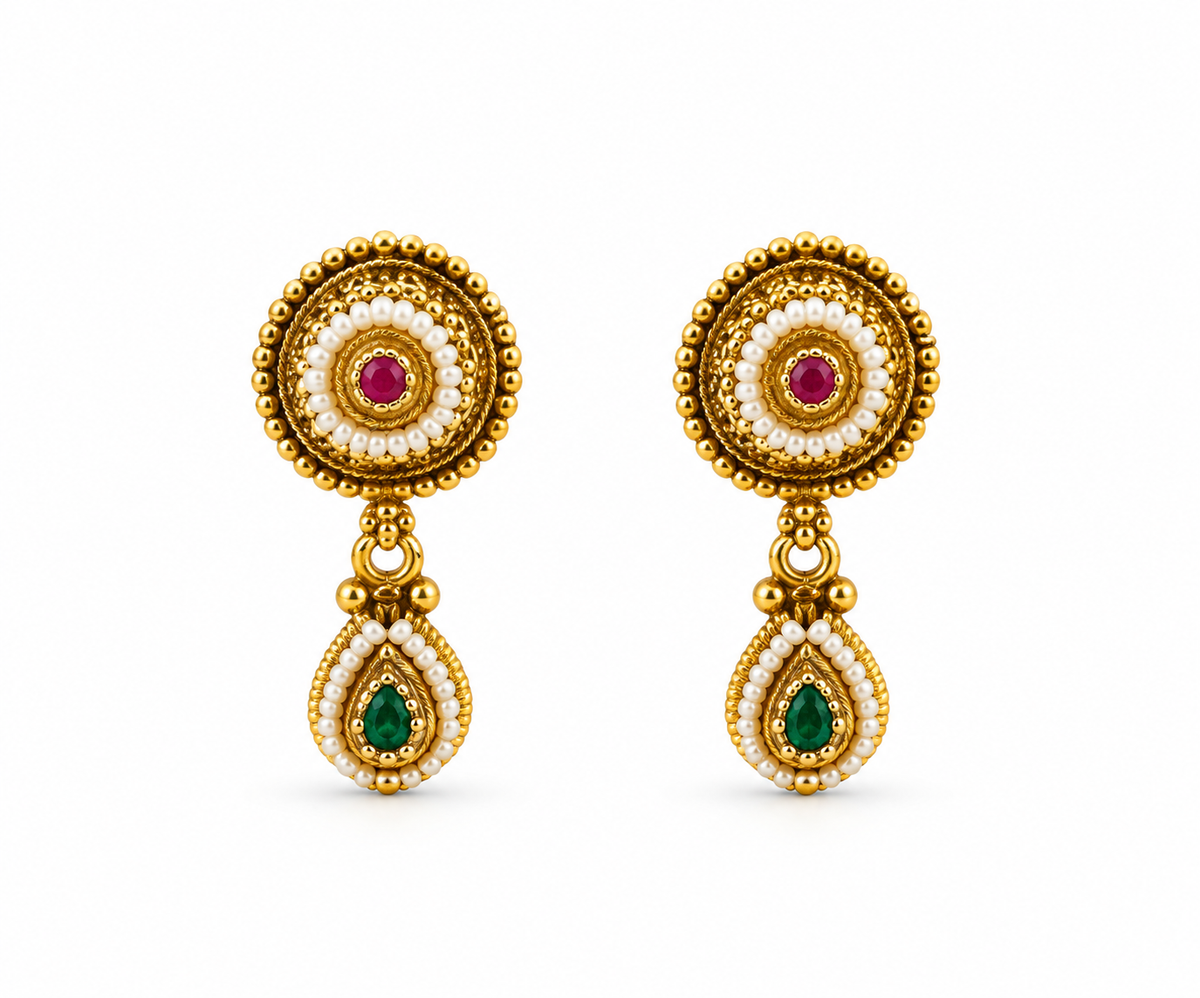 Gold-tone floral halo necklace set displayed on white jewellery stands, featuring a round pendant with green and magenta-pink accents, a decorative beaded chain, and matching earrings with green teardrop-shaped drops.