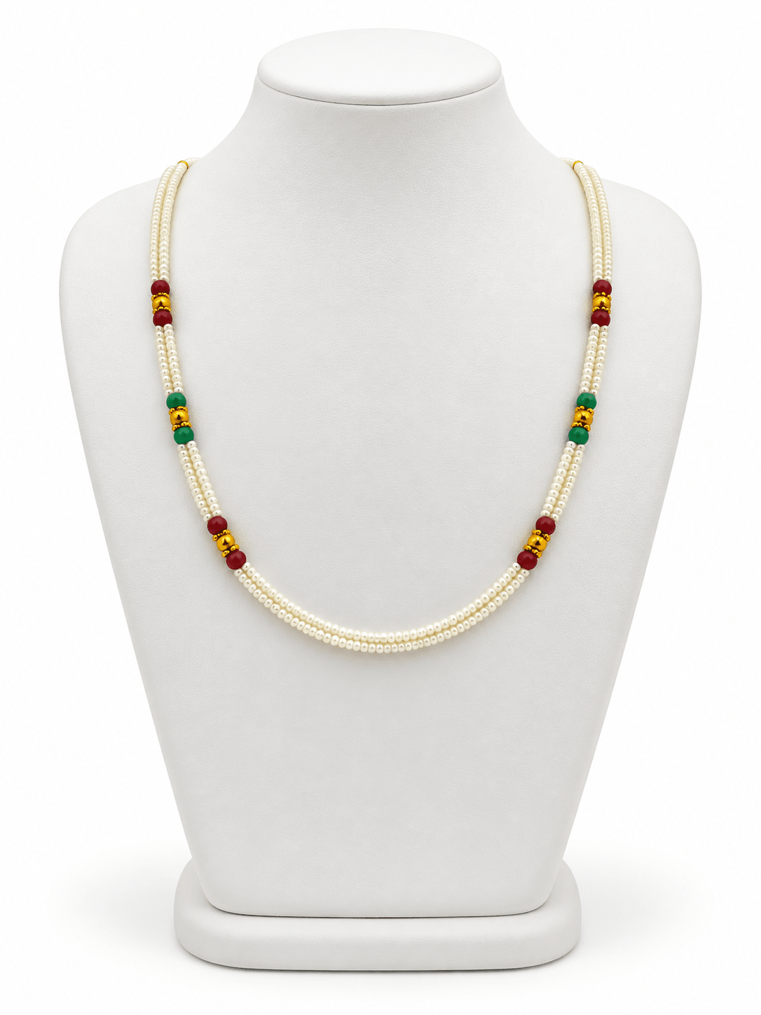 Double-strand white beaded necklace with deep red and green bead accents, decorative gold-tone elements and a gold-tone clasp displayed on a white necklace stand. - bhavmayi