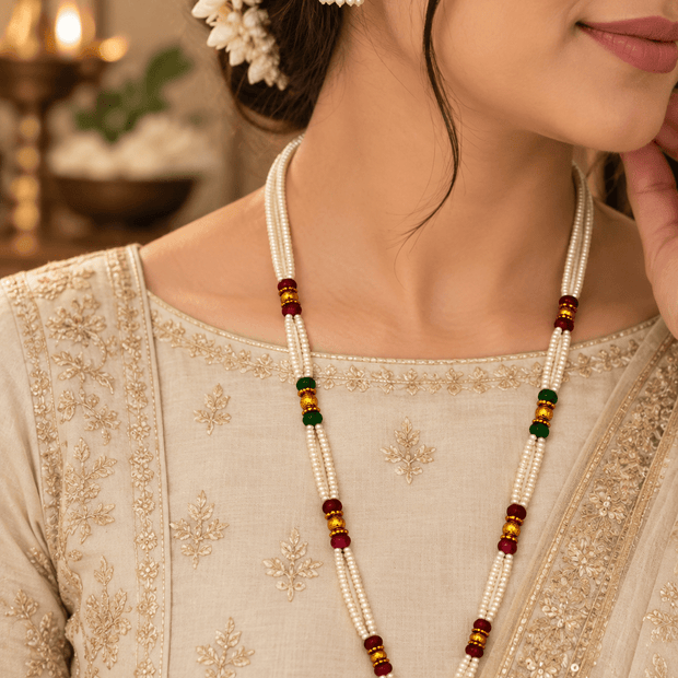 Bhavmayi traditional multi-strand ivory pearl necklace set with maroon and dark green bead accents, gold-tone earrings.