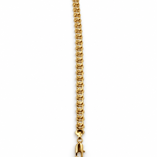 Golden curb chain bracelet with closely connected rounded links and a visible lobster-style clasp