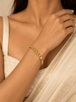 Gold-tone bracelet featuring a continuous chain of rounded interlocking links with a twisted appearance, shown separately and worn around a woman's wrist. - bhavmayi