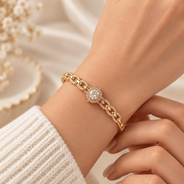 Gold-tone bracelet with a square-shaped central motif, large clear faceted centrepiece, surrounding rows of small clear decorative stones and an intricate openwork linked band. - bhavmayi