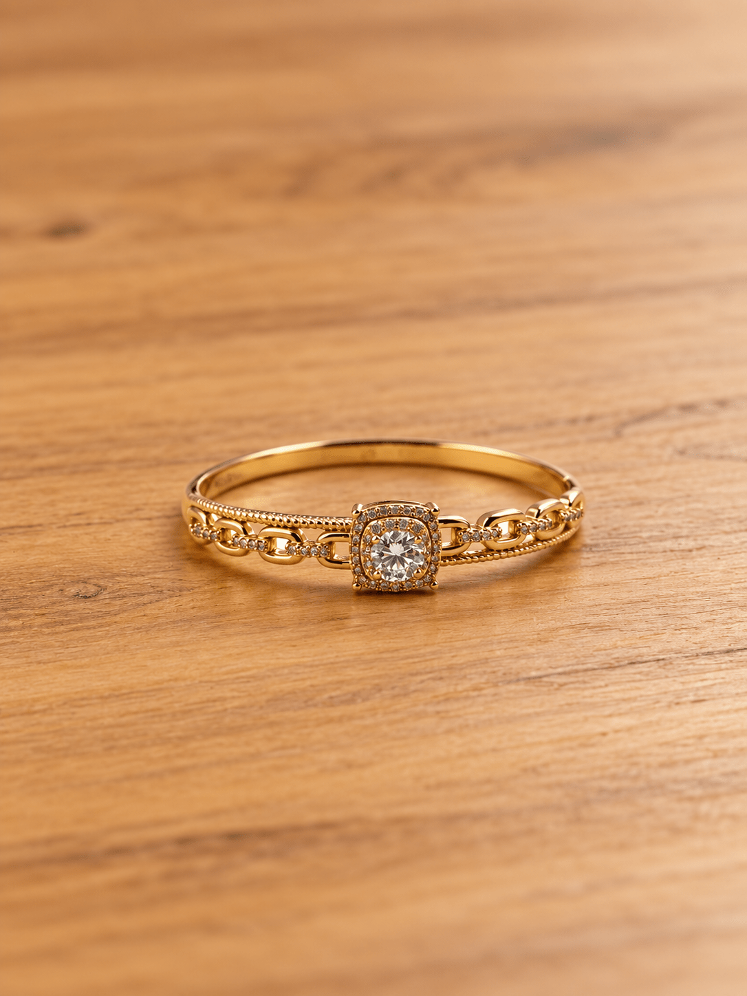 Gold-tone bracelet with a square-shaped central motif, large clear faceted centrepiece, surrounding rows of small clear decorative stones and an intricate openwork linked band. - bhavmayi