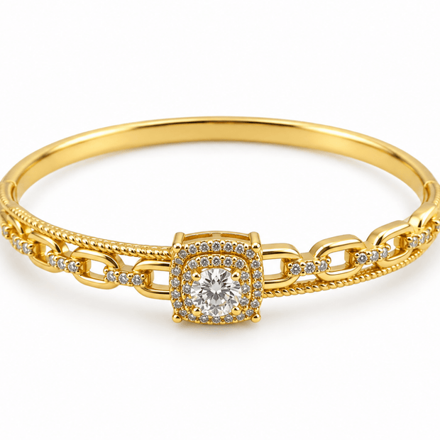 Gold-tone bracelet with a square-shaped central motif, large clear faceted centrepiece, surrounding rows of small clear decorative stones and an intricate openwork linked band. - bhavmayi