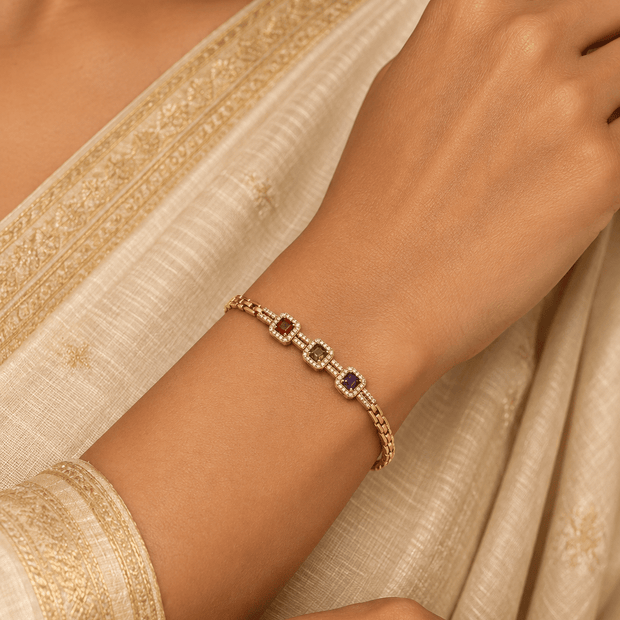 Golden link bracelet with three coloured centre accents and clear decorative detailing