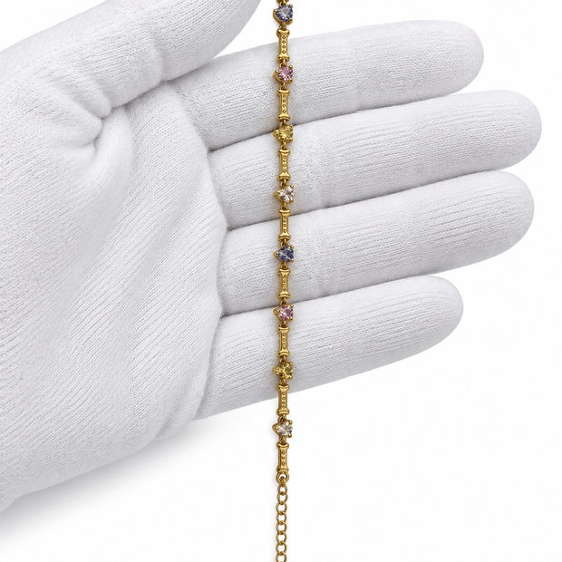 Gold-tone chain bracelet featuring geometric golden links and multicoloured blue, purple, pink, green and clear decorative accents, shown separately and worn on a wrist. - bhavmayi