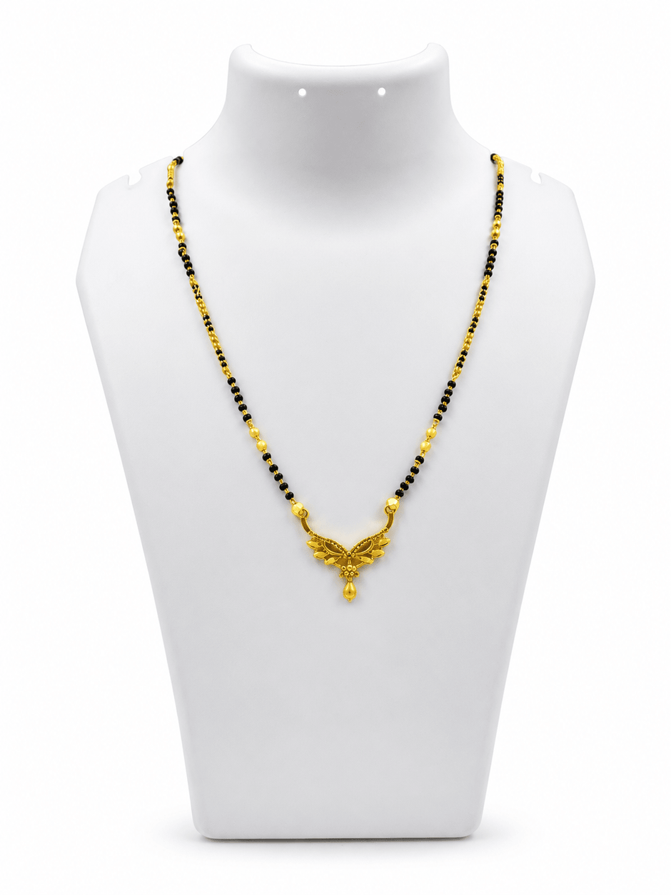 Gold-tone mangalsutra necklace with black bead chain, symmetrical leaf-shaped centerpiece, clear stone embellishments and a decorative central drop detail, displayed on a white background. - bhavmayi