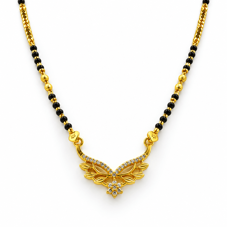 Gold-tone mangalsutra necklace with black bead chain, symmetrical leaf-shaped centerpiece, clear stone embellishments and a decorative central drop detail, displayed on a white background. - bhavmayi