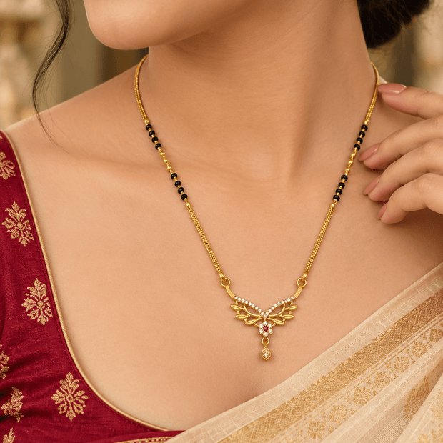 Bhavmayi gold-tone mangalsutra necklace featuring black beads, a floral pendant with white stone-like accents.