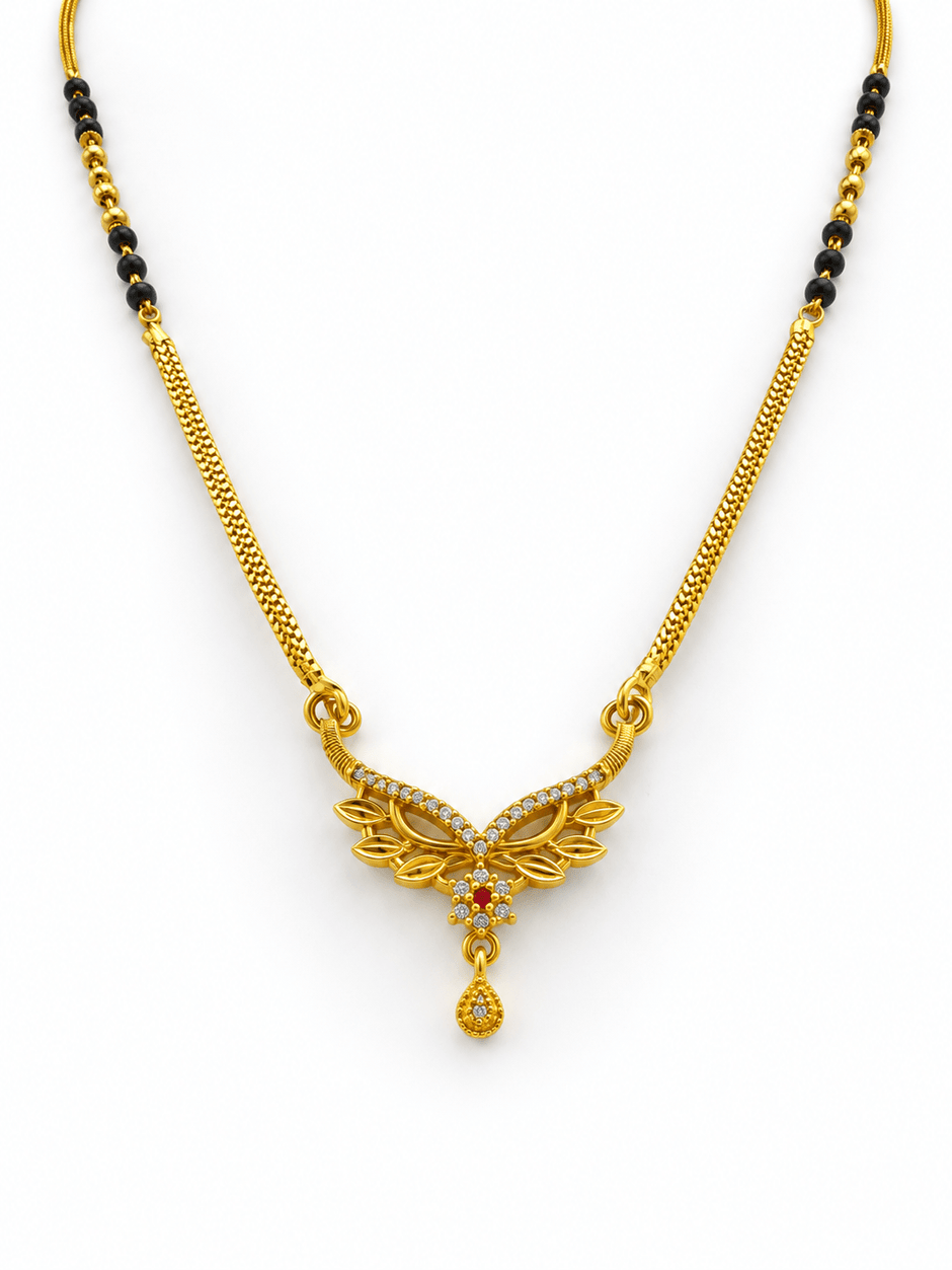Gold-tone mangalsutra necklace with black beads, symmetrical floral leaf-shaped centerpiece, clear decorative stones, red center accent, and dangling teardrop pendant on a white background. - bhavmayi