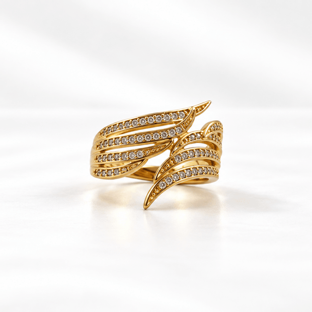 Golden statement ring with layered leaf-like curved bands and rows of clear accent details
